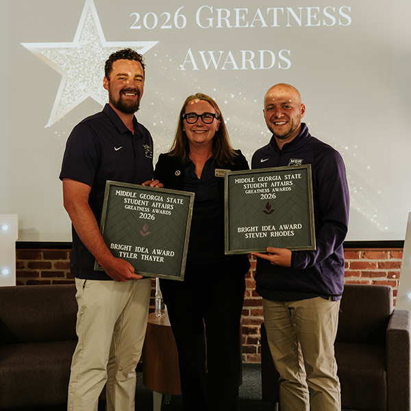 Dr. Jennifer Brannon and award recipients Tyler Thayer and Steven Rhodes smile while holding individual plaques that read, "Middle Georgia State Student Affairs Greatness Awards 2026 - Bright Idea Award, Tyler Thayer" and "Middle Georgia State Student Affairs Greatness Awards 2026 - Bright Idea Award, Steven Rhodes."